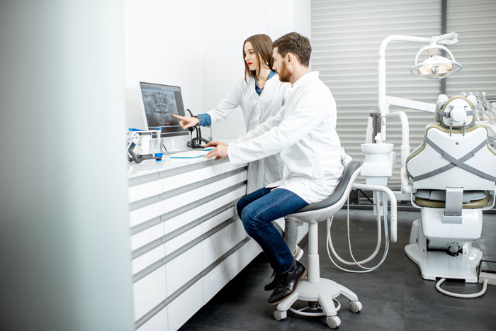 team of dentists looking at an x-ray in the office